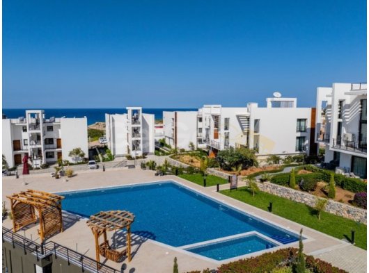 1 yatak odalı modern bahçeli daire + full eşyalı + ortak yüzme havuzu + bar + plaja ve süpermarkete yürüme mesafesinde + deniz ve dağ manzarası