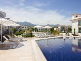 Deniz kıyısında gelişen 2 yatak odalı zemin kat daire + tamamen mobilyalı + ortak havuzlar + restoran + SPA merkezi + süpermarket + eczane + plaja yürüme mesafe